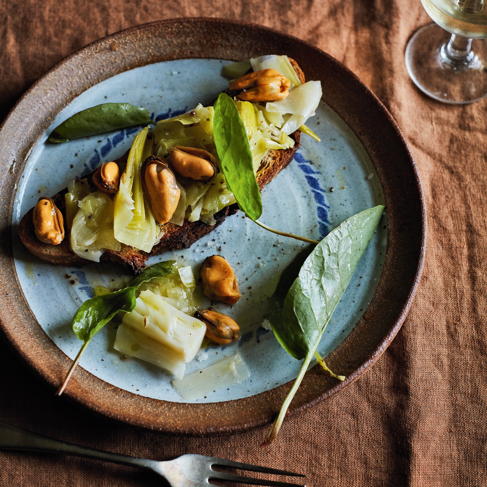 Braised leeks with sorrel and mussels on toast